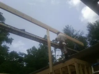 Carpenter setting a ridge beam over a new addition frame — Ice Dam Removal by Roofing Brothers in Hawesville