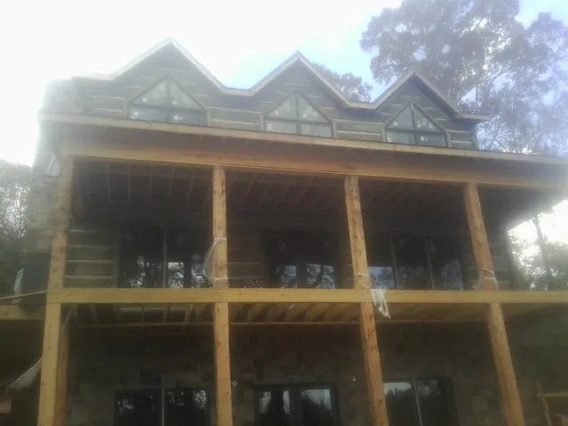 Dormers and porch framing on a large log home under construction — Roof Coating work by our crew in Hawesville