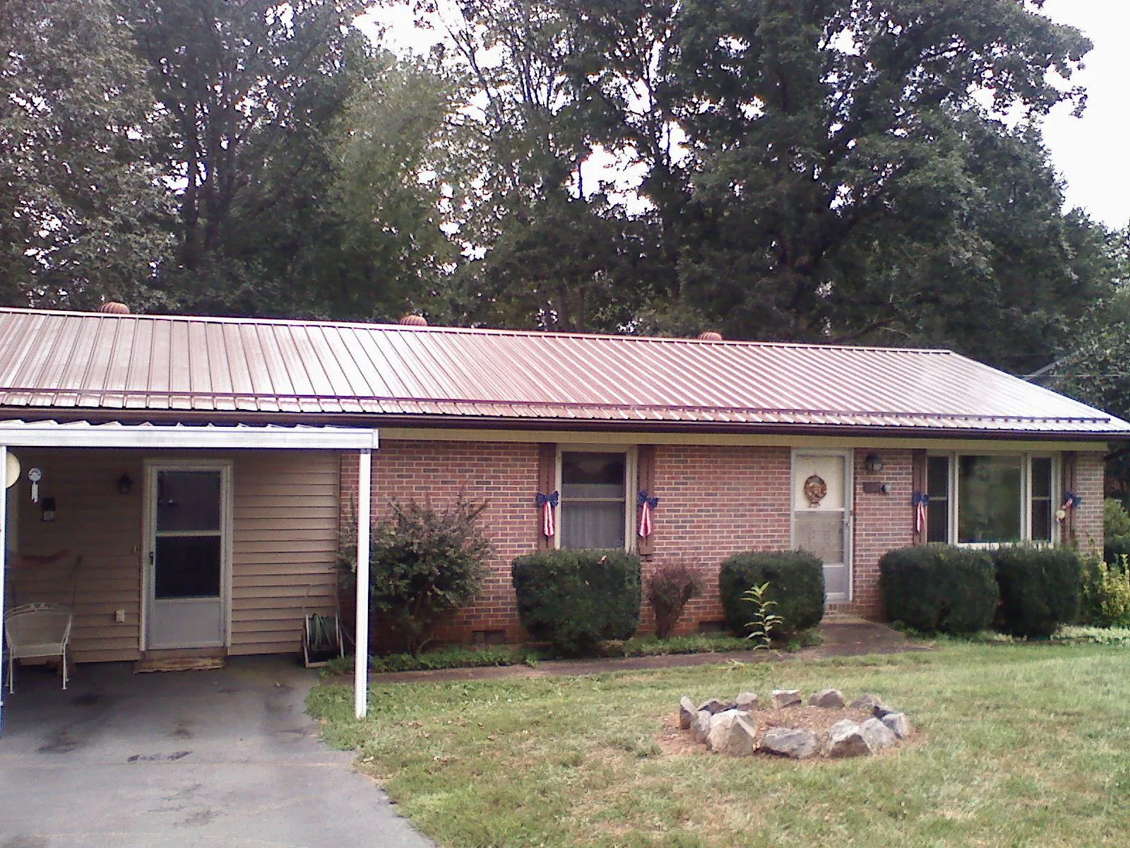 Bronze metal roof and carport on a brick ranch home — Roof Repair work by our crew in Hawesville